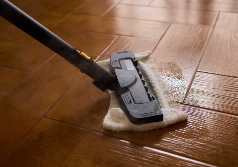steam-mop-with-white-pad House cleaner using steam mop with white cloth pad to clean floor