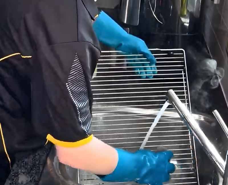 Maid2Match professional house cleaner cleaning oven with hot, soapy water