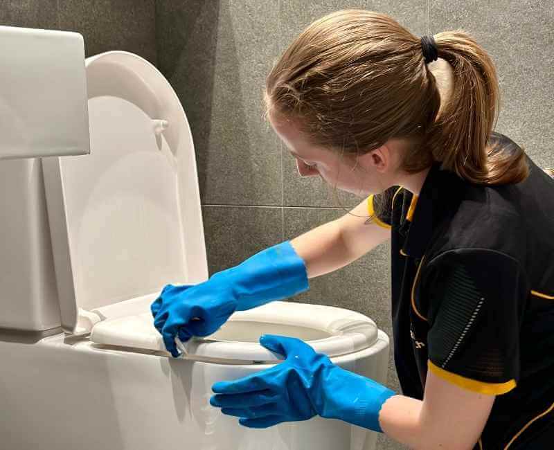 professional-DVA-cleaner-cleaning-toilet Maid2Match Brisbane professional DVA cleaner cleaning toilet in the bathroom