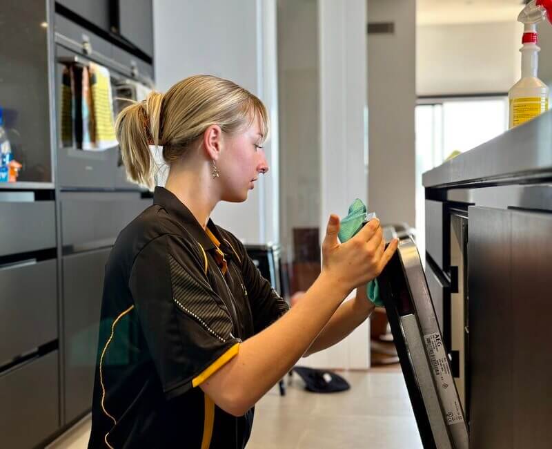 Brisbane-trained-NDIS-cleaner-cleaning-oven Maid2Match Brisbane NDIS cleaner Casey cleaning an oven