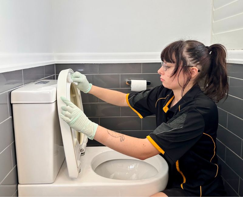 Maid2Match professionally trained house cleaner cleaning under toilet seat