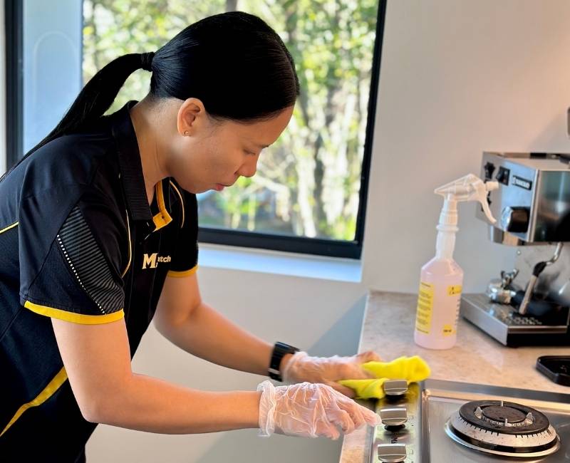 Maid2Match professionally trained house cleaner Paige cleaning stove top
