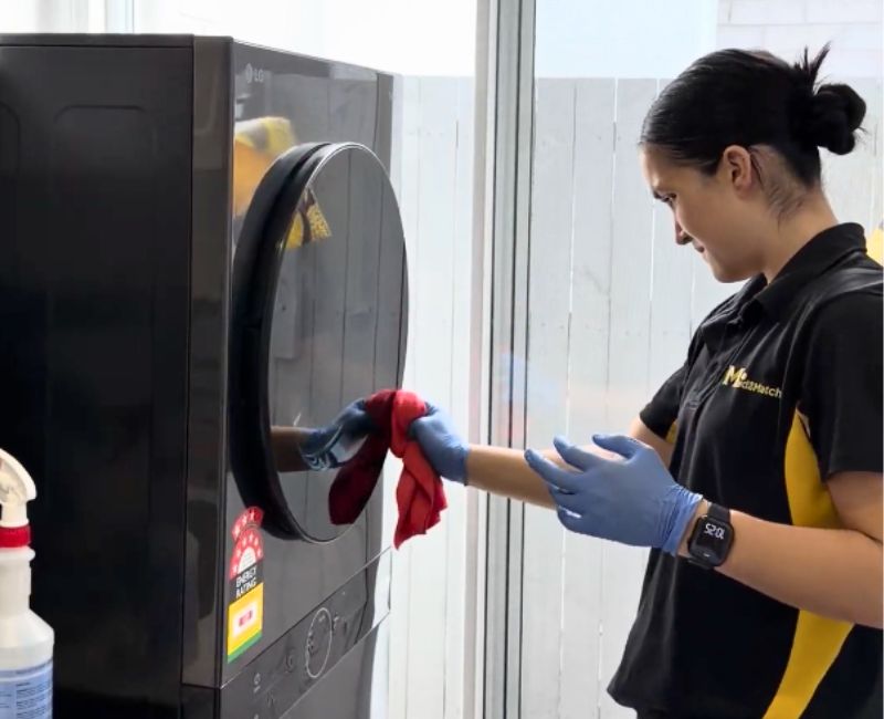 Maid2Match professional cleaner cleaning front load washer surface with microfibre cloth