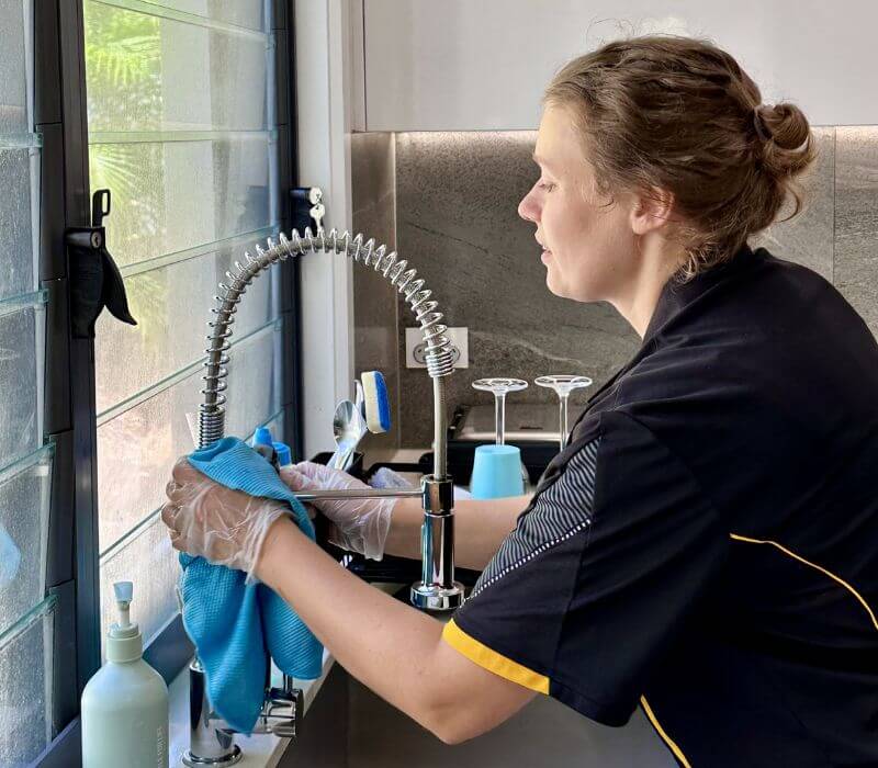 Maid2Match trusted house cleaner wiping kitchen sink faucet with microfibre cloth