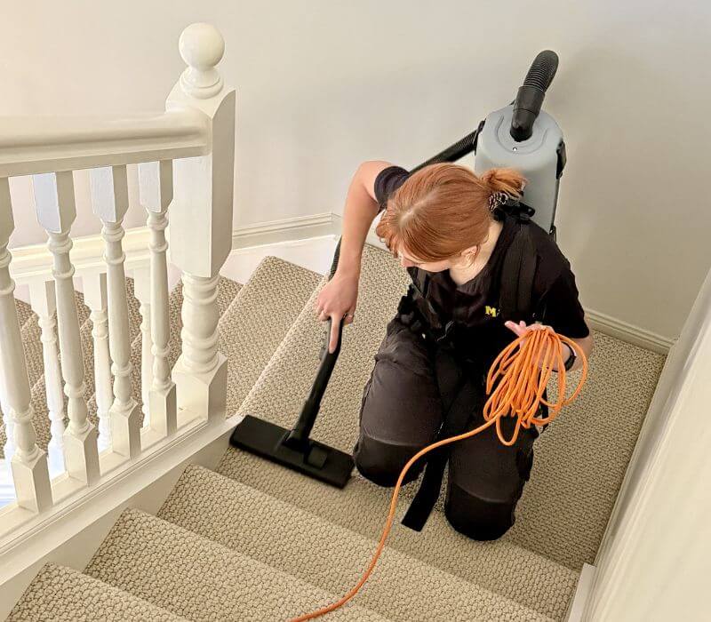 Maid2Match Brisbane permanent employee cleaner Jacinta vacuuming house stairs with full equipment