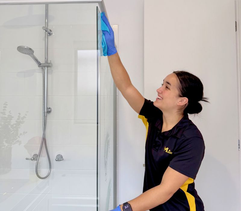 Maid2Match Brisbane fully trained professional cleaner Timea cleaning shower glass in a house clean