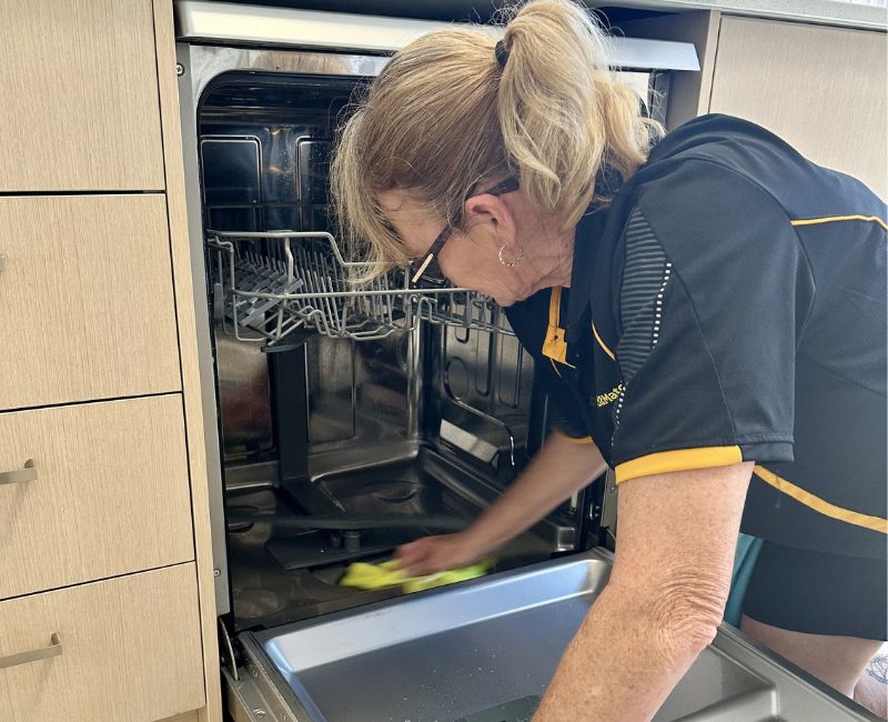 Maid2Match cleaner Liz cleaning dishwasher interior with microfibre cloth