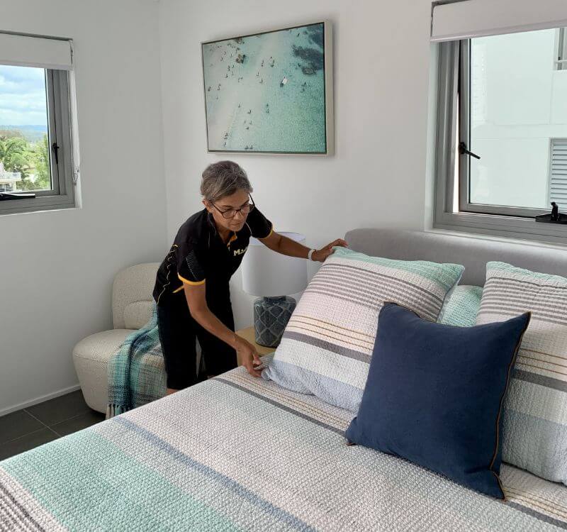 Maid2Match house cleaner Lorena arranging pillows and covers on the bed