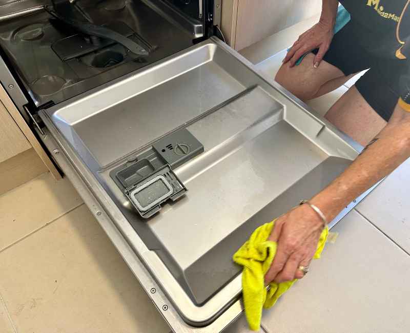 Maid2Match cleaner wiping dishwasher door gaskets and seals with microfibre cloth