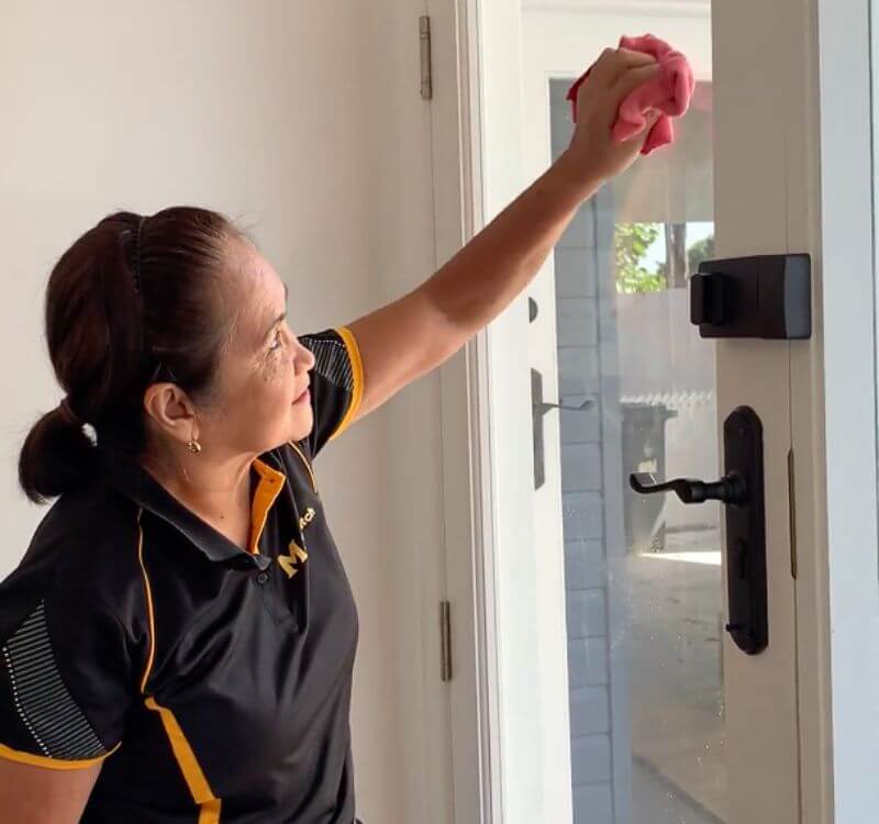 Maid2Match professional house cleaner Lorena cleaning entrance glass door