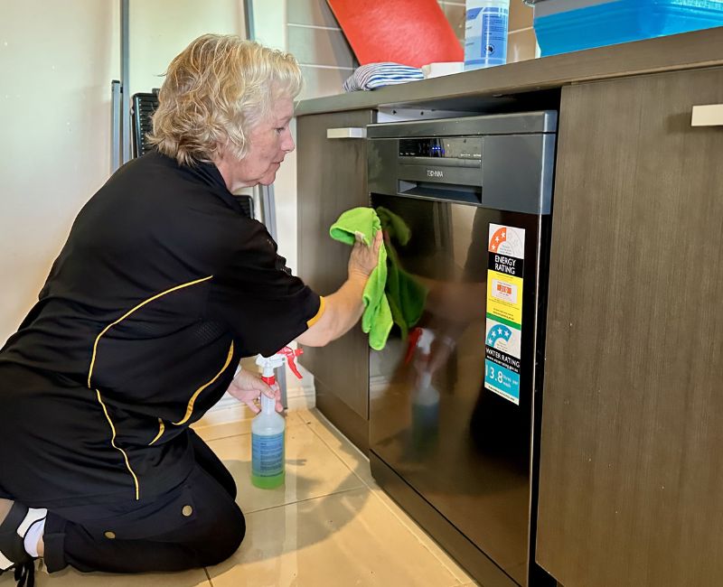 Maid2Match house cleaner Nicola wiping dishwasher door and exterior
