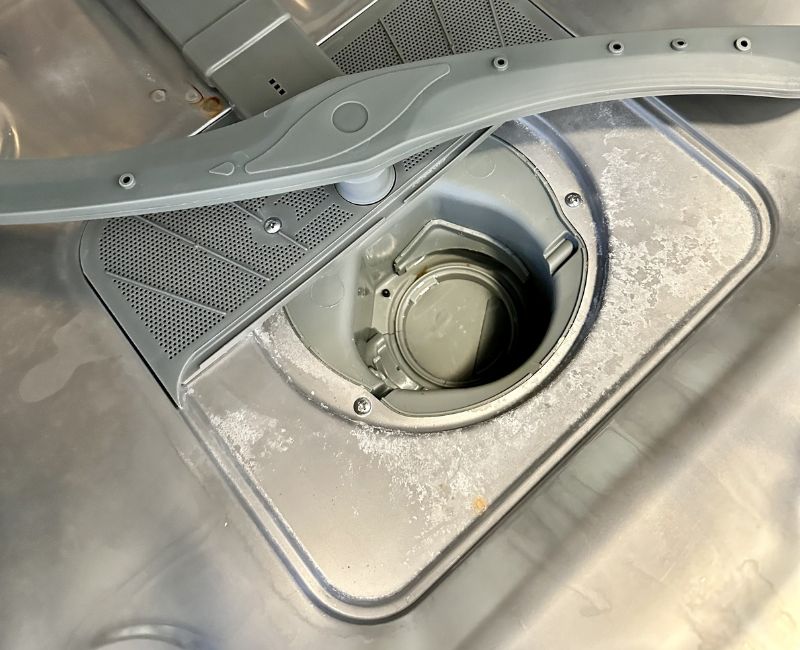 close up of a dirty dishwasher drain area
