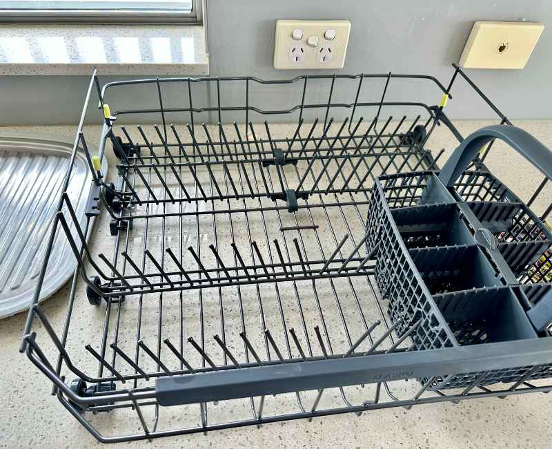 Clean dishwasher racks set on kitchen benchtop near the sink