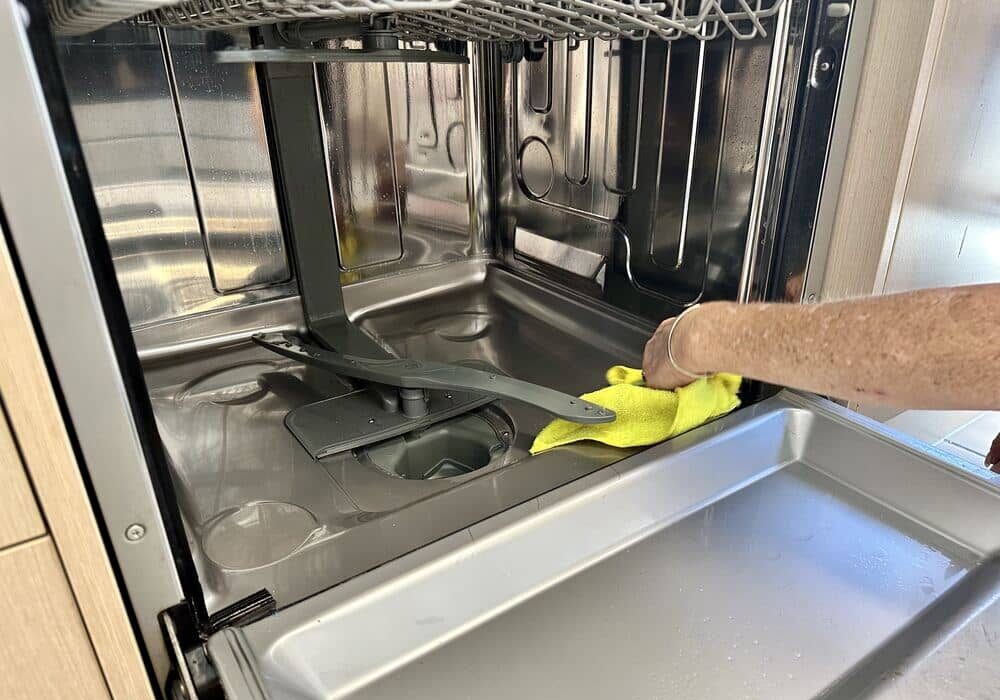 cleaning-inside-smelly-dishwasher house cleaner cleaning the inside of dishwasher to avoid bad smell