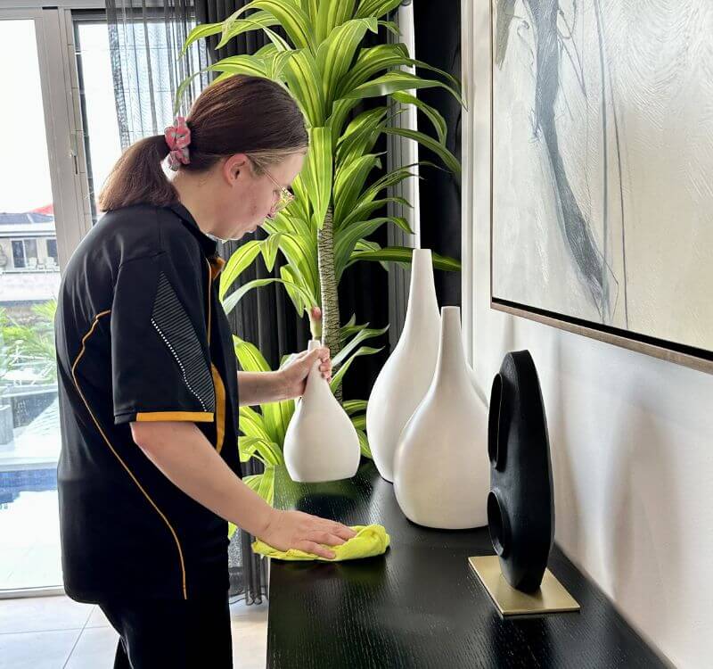 Maid2Match fully trained house cleaner cleaning around living area surfaces