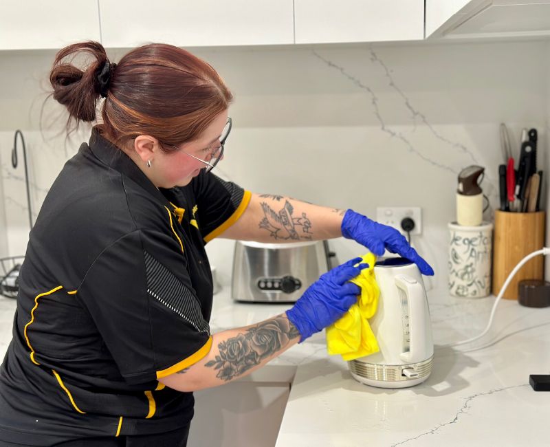 Maid2Match Geelong experienced cleaner Paris wiping dirt off kettle