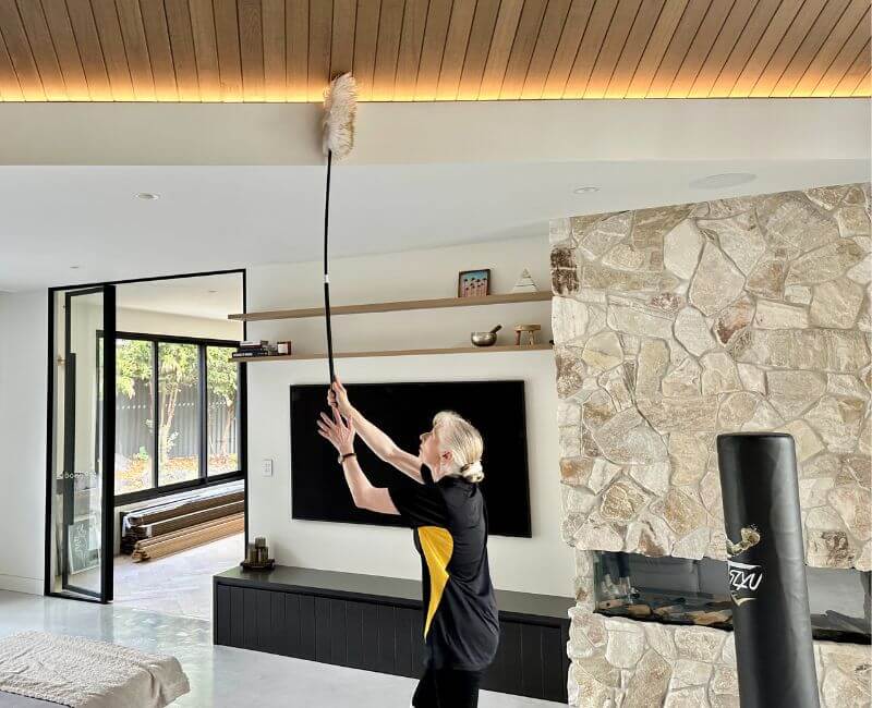 Maid2Match Gold Coast professional house cleaner dusting the area near the ceiling