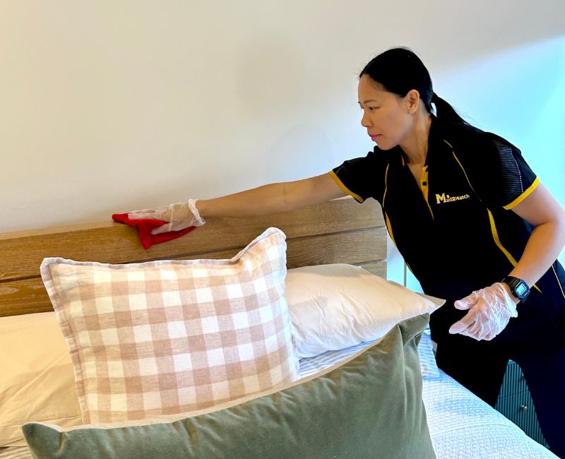Maid2Match house cleaner Paige cleaning the bed headboard