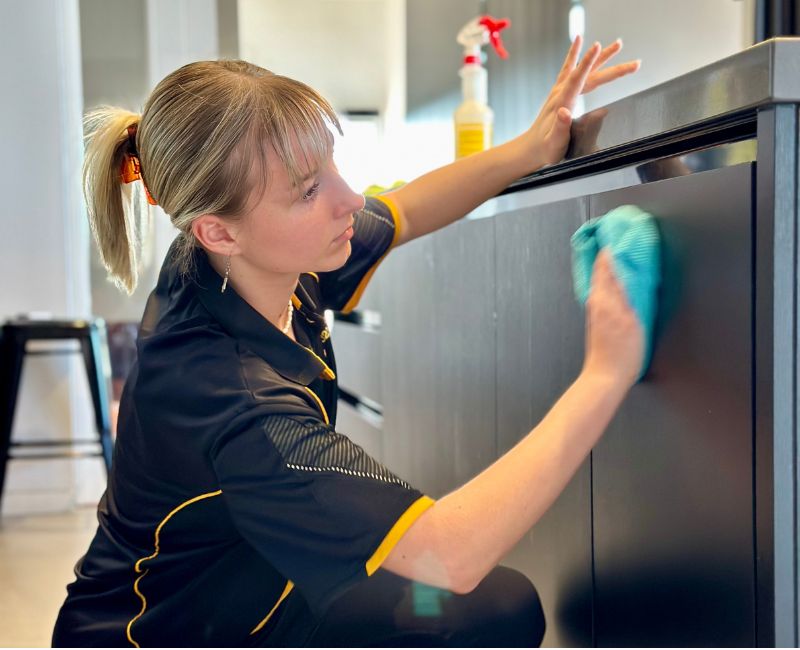 Maid2Match friendly and police-vetted house cleaner cleaning kitchen cabinets