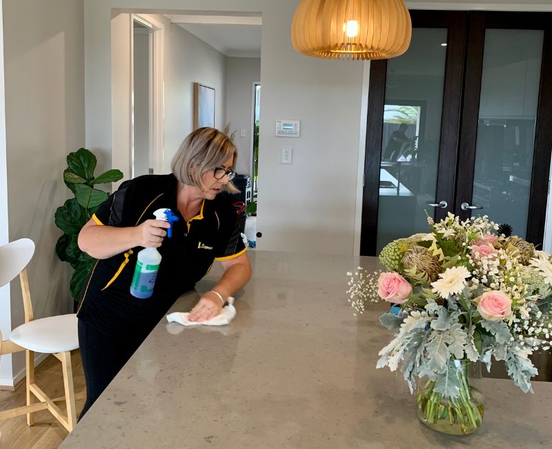 Professional house cleaner cleaning dining table