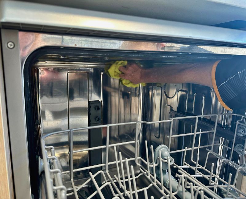 Maid2Match house cleaner cleaning the top part of a dishwasher