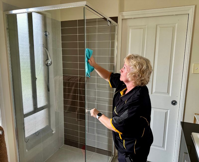 Experienced cleaner at Maid2Match Gold Coast cleaning shower glass