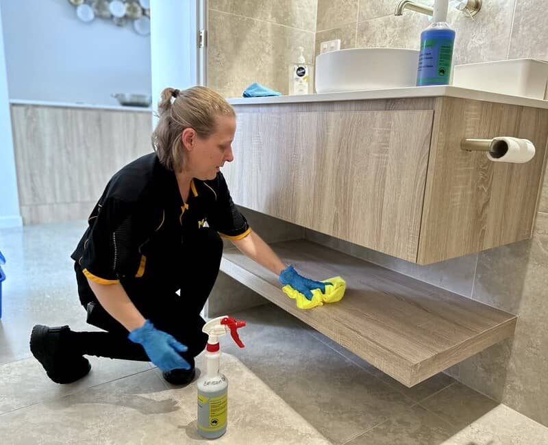 house cleaner Nicole cleaning cabinet in the bathroom