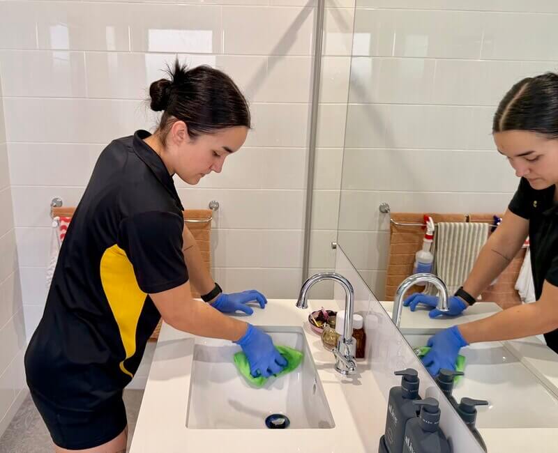 Brisbane house cleaner Timea cleaning the bathroom sink