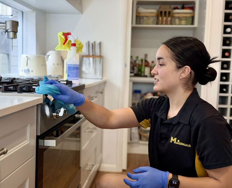 Maid2Match friendly house cleaner Timea cleaning the oven exterior
