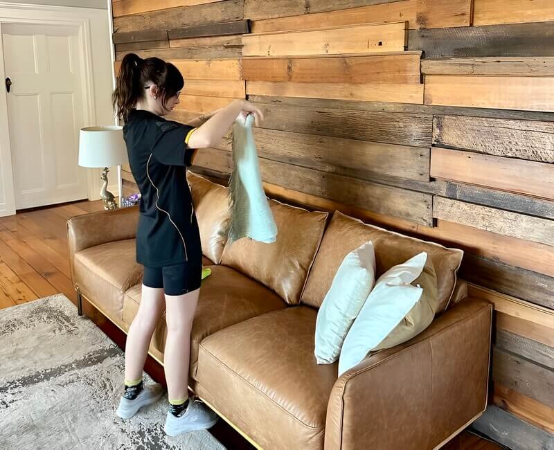 house cleaner tidying up in an empty living room