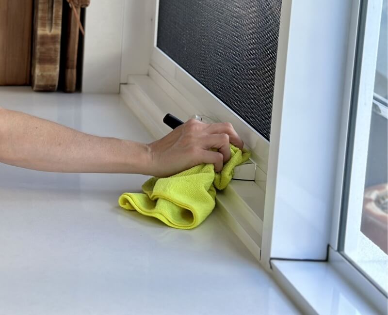 Wiping surfaces around the kitchen window