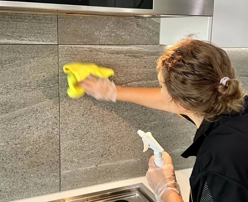 Cleaning kitchen splashback with methylated spirits spray