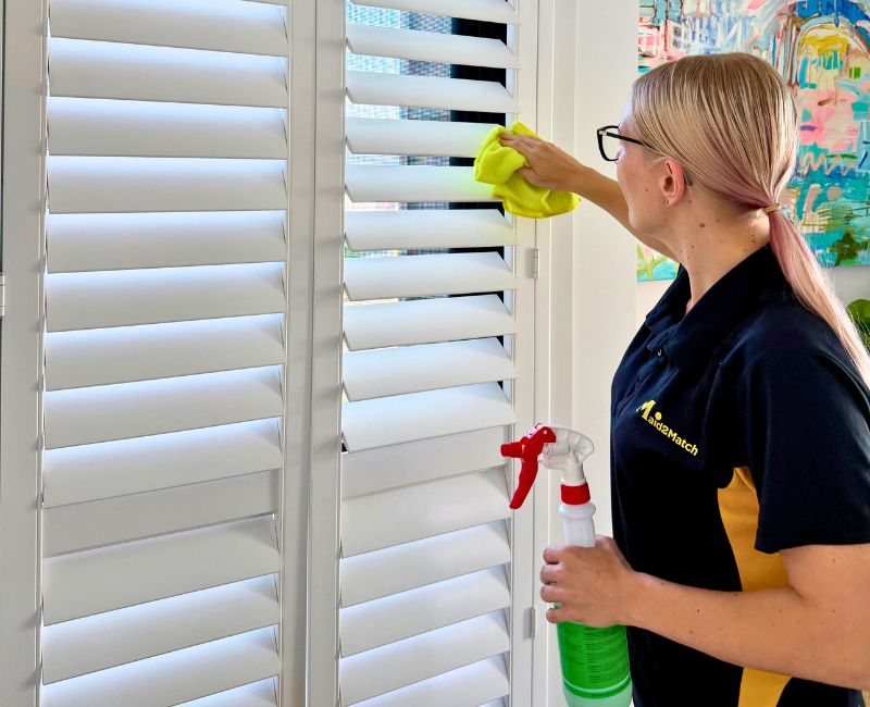 Maid2Match experienced cleaner cleaning and dusting the window blinds