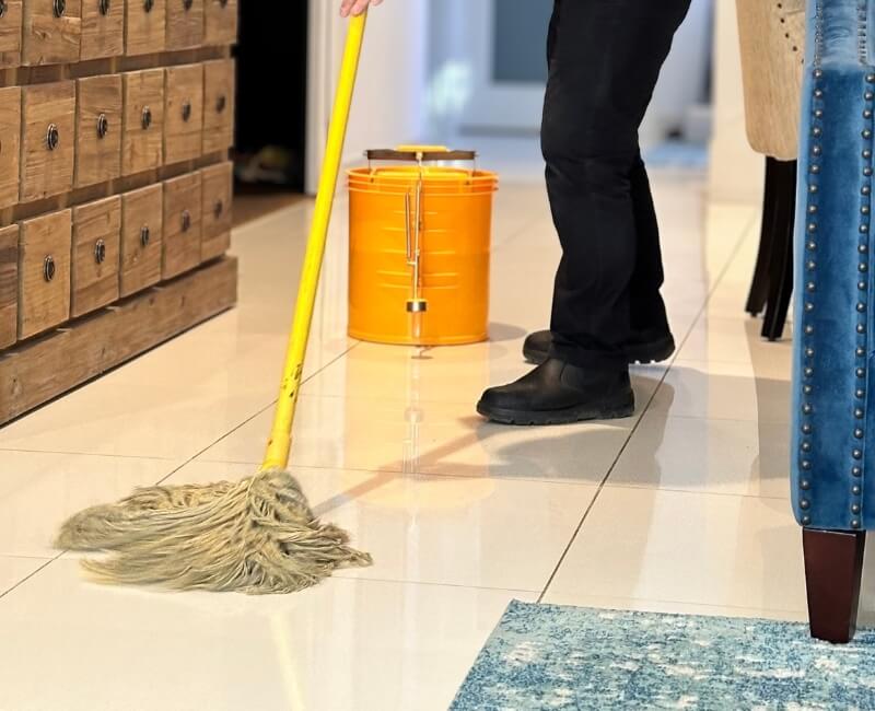 Cleaning tiled floor with string mop