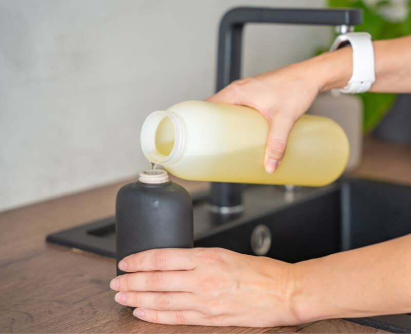 pouring a liquid soap on a new container